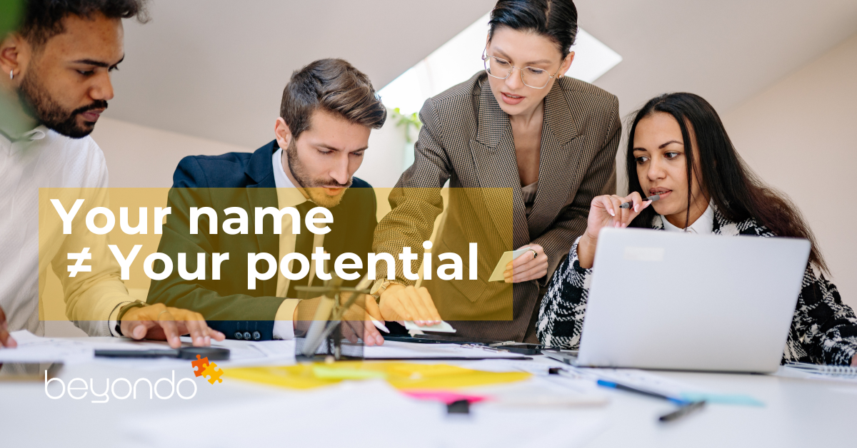 People working together in a modern office setting with the message ‘Your name ≠ Your potential’ displayed on the image.